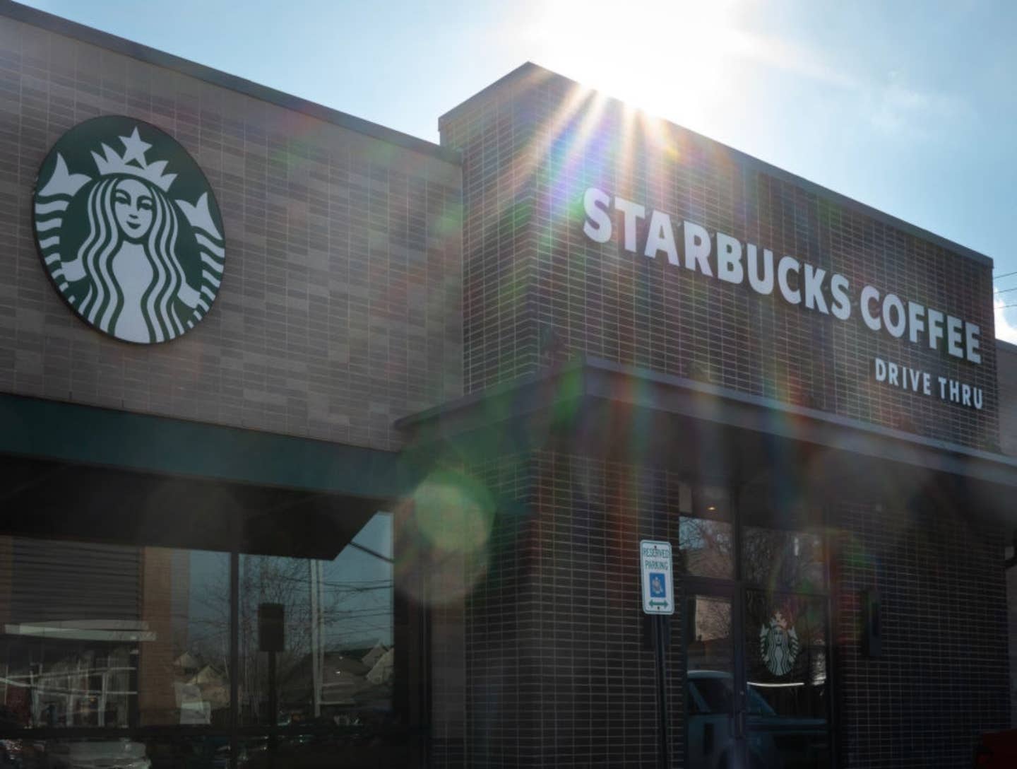 Exterior of a Starbucks coffee shop shows the logo and signage on a brick facade.