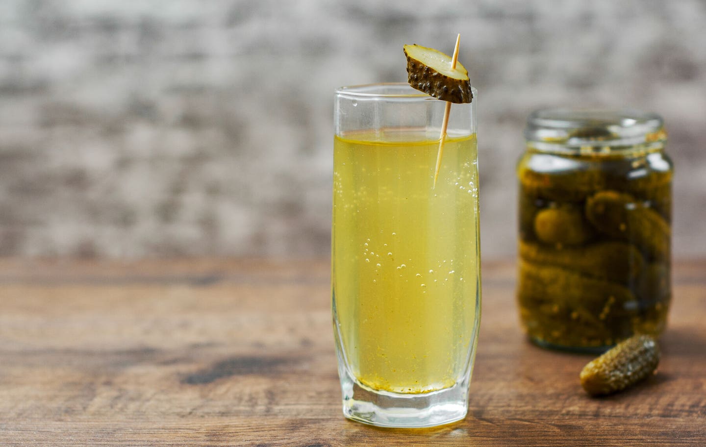 Pickle Juice in a jar of pickles and a glass.