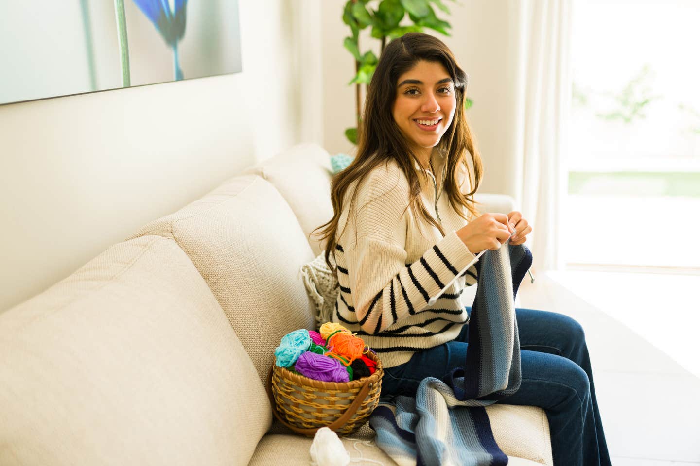 A young woman doing an "old people" thing by knitting.