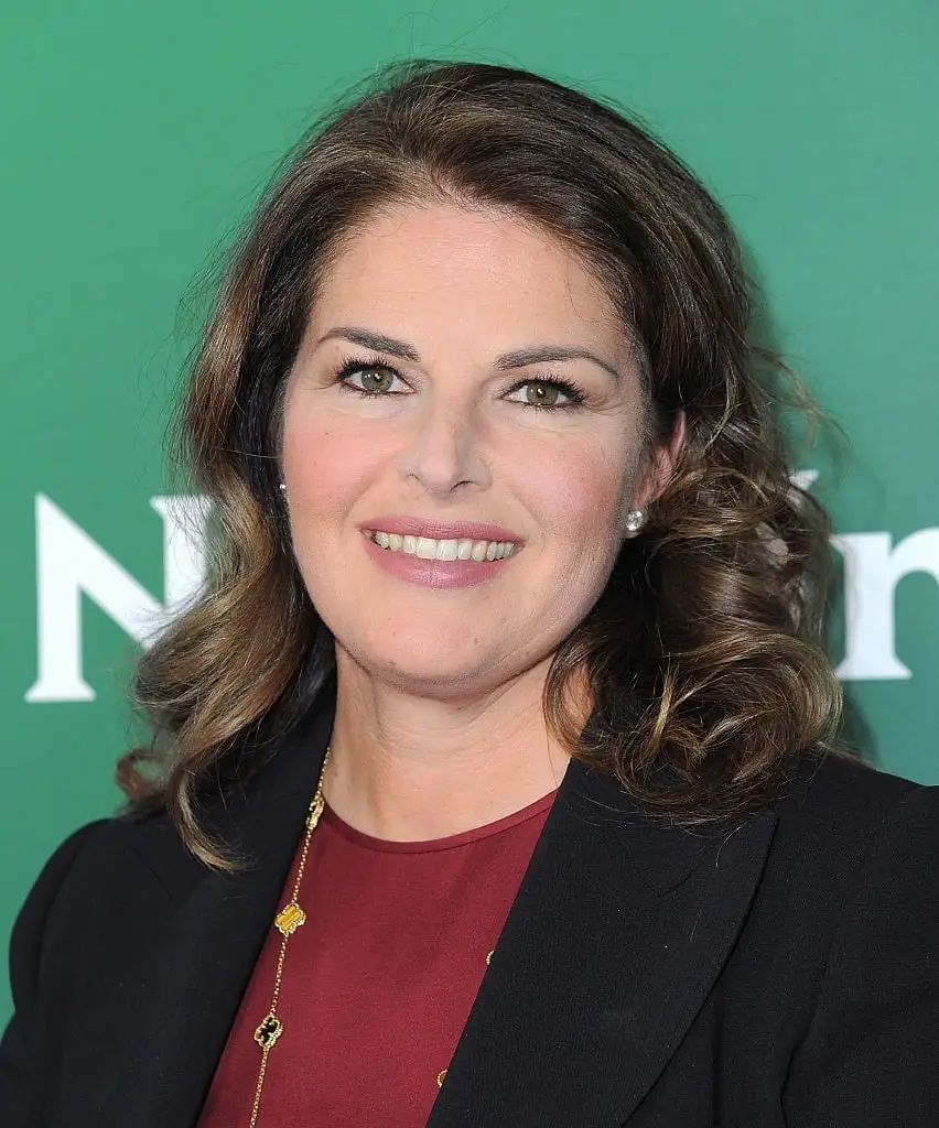 elizabeth blau in front of green step and repeat sign