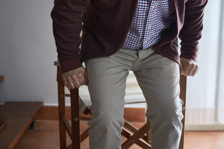 Older man getting up from out of his chair.