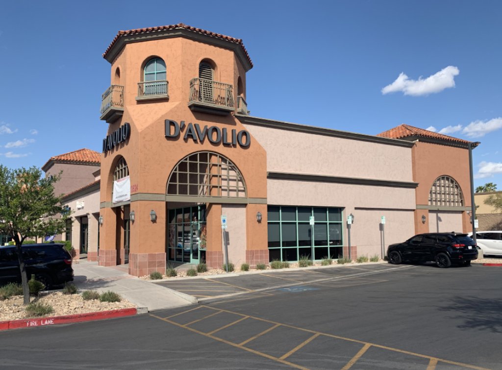 A corner restaurant is under a blue sky. The signage reads "D'Avolio" over a terra cotta colored stucco.