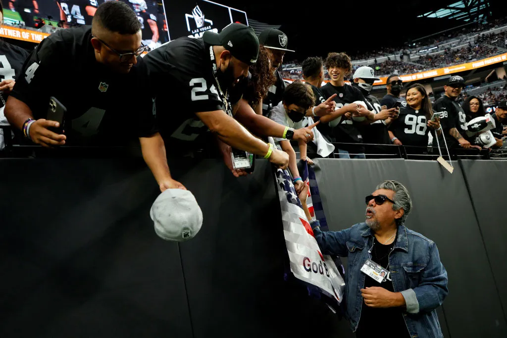 George Lopez at a Raiders game in Las Vegas, talking with fans in the stand. 