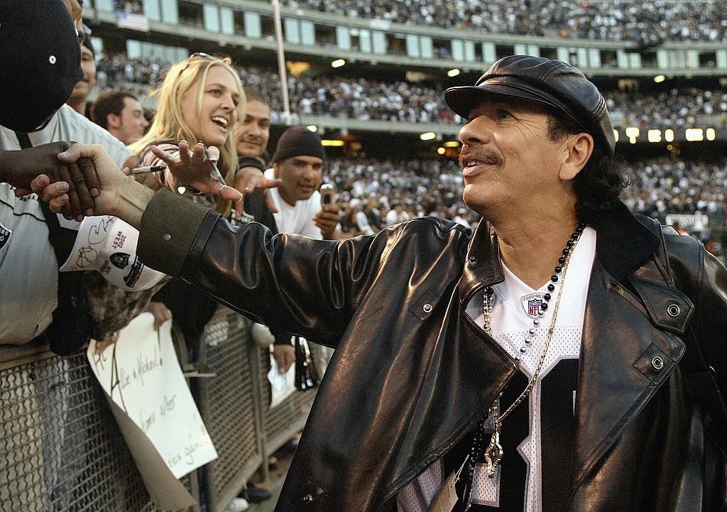 Recording artist Carlos Santana shakes hands with the fans during the game between the Oakland Raiders and the Kansas City Chiefs at Network Associates Coliseum on October 20, 2003 in Oakland, California. The Chiefs defeated the Raiders 17-10.